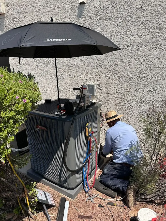 HVAC technician performing outdoor AC maintenance in Hudson